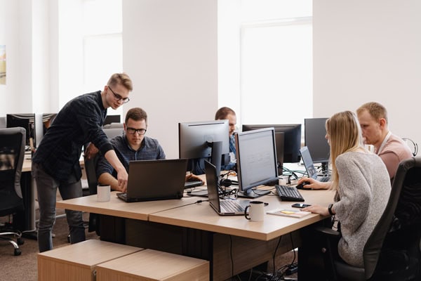Medical IT support team collaborating in a modern office, managing healthcare networks and digital system